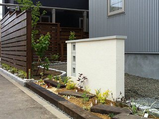 ウッドフェンス、植栽、塗り壁で歩道境界線をデザイン